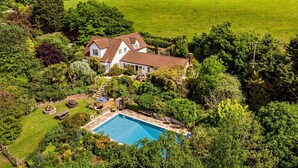 A large house with a swimming pool surrounded by lush greenery. - Medlar House - Six Bedroom Villa, Sleeps 20 (Cheriton Fitzpaine)
