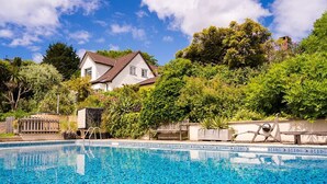 A swimming pool with a house in the background. - Medlar House - Six Bedroom Villa, Sleeps 20 (Cheriton Fitzpaine)