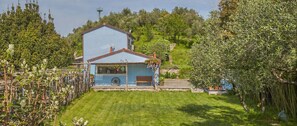 A two-story house with a blue exterior, a front porch, and a small garden area. - Villa Idyll - Two Bedroom Villa, Sleeps 6 (La Spezia)