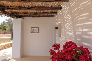 A room with a white wall, a wooden ceiling, and a sign that reads 'CAN PLANA'. - New! Villa Plana Menut (Can Escandell)