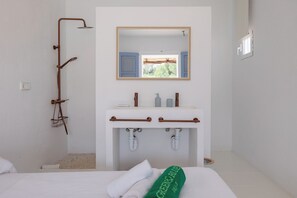 A bathroom with a shower, a sink with a mirror, and a bed with a towel. - New! Villa Plana Menut (Can Escandell)