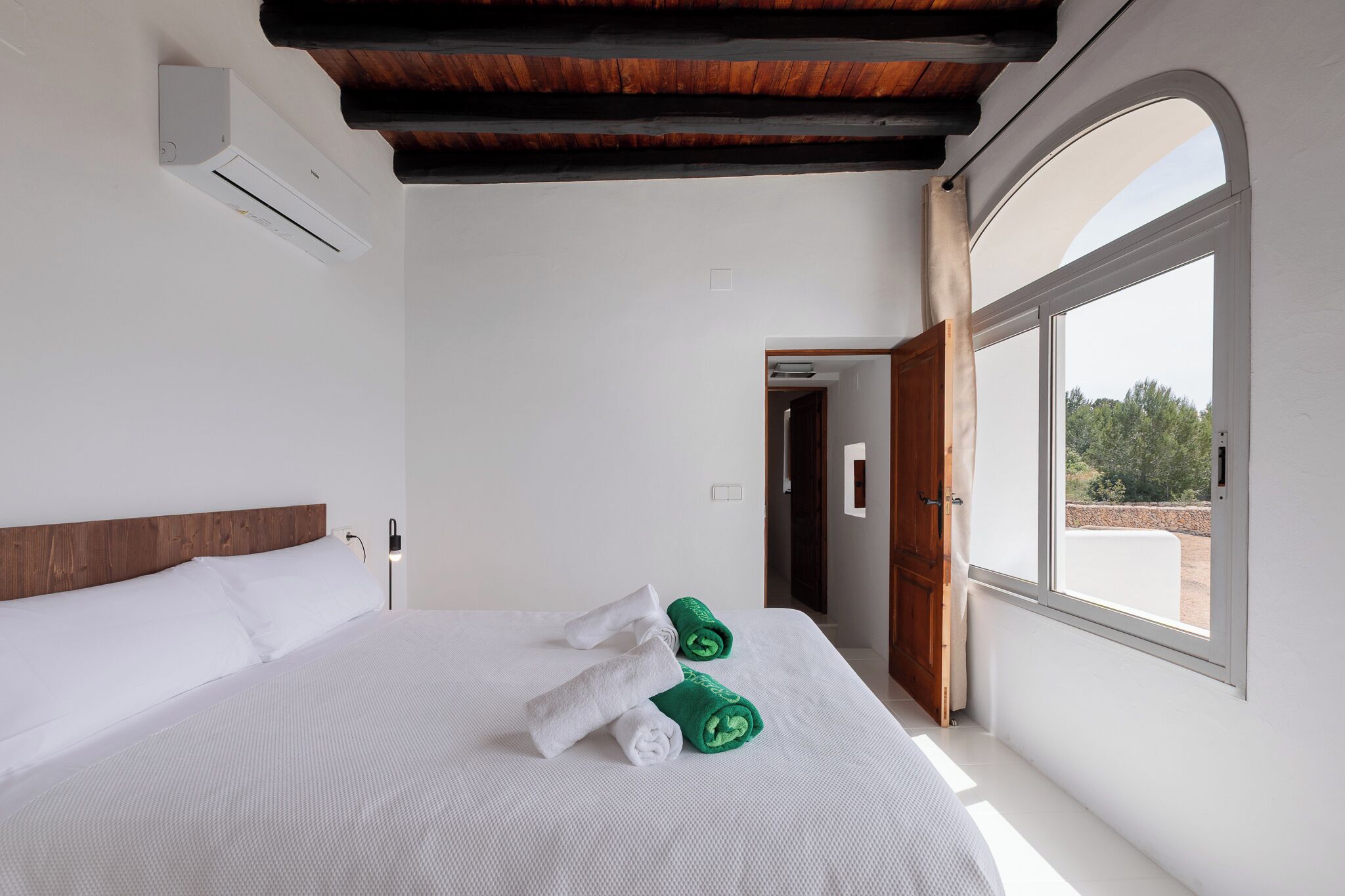 Une chambre à coucher avec un lit, une fenêtre et un appareil de climatisation.