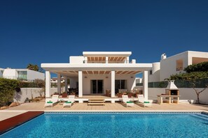 A modern house with a swimming pool, outdoor seating, and a covered patio. - New! Villa Lina - Four Bedroom Villa, Sleeps 8 (Ibiza)