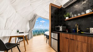 A tented accommodation with a kitchen area, a dining table, and chairs. - Glamping Collective Chattanooga (Trenton)