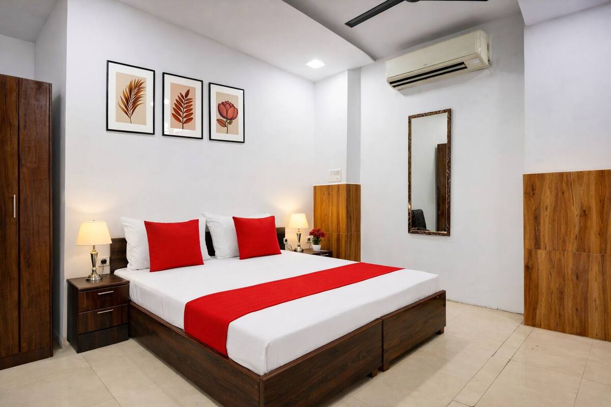 Een hotelkamer met een houten bed, witte muren en een rode accentkleur.
