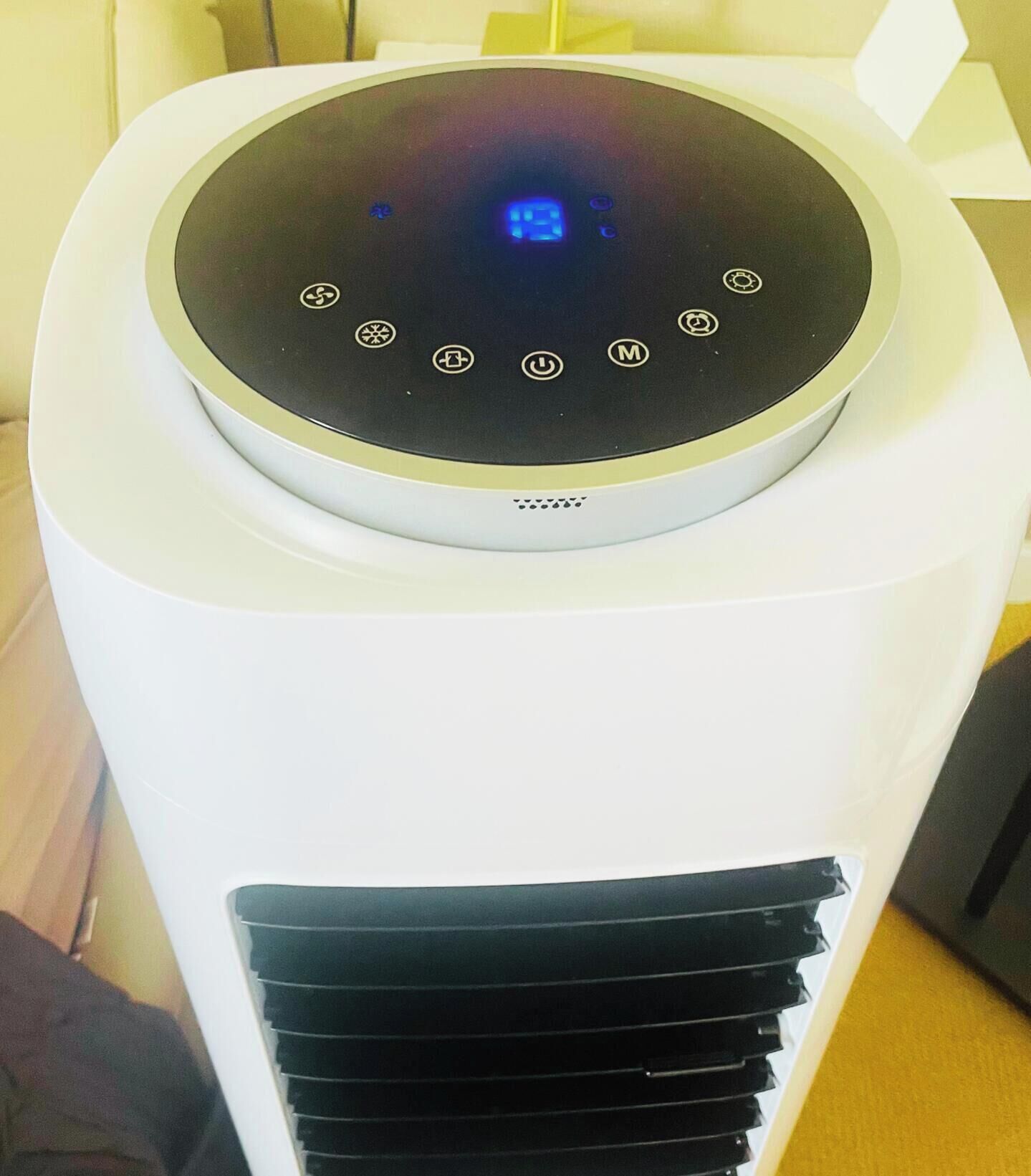 Een witte luchtreiniger met een rond bedieningspaneel en een ventilatieopening onderaan.