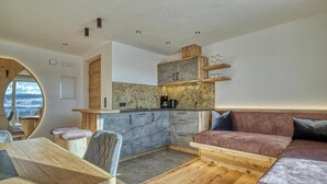 Un espace de vie compact comprenant une cuisine, un coin repas et un coin salon.