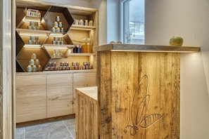 Un comptoir en bois avec des pots de miel et un petit ustensile pour servir le miel.