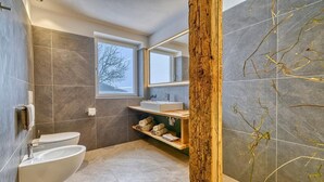 A modern bathroom with a toilet, sink, and built-in shelves. - Beautiful Apartment with Mountain View – Silva (Avelengo)