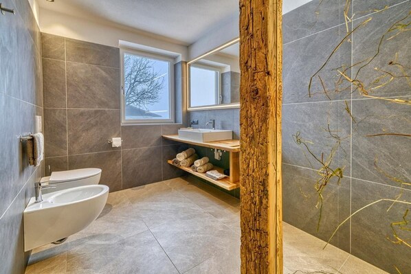 A modern bathroom with a toilet, sink, and built-in shelves. - Beautiful Apartment with Mountain View – Silva (Avelengo)
