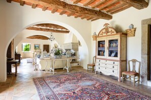 A spacious room with a large rug, wooden furniture, and a bookshelf.