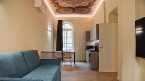 Un salon moderne comprenant un canapé, un coin repas et une cuisine.