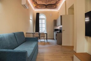Ein modernes Wohnzimmer mit Sofa, Essbereich und Küche.