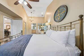 A bedroom with a large bed, a chandelier, a ceiling fan, and a decorative wall plate. - 🏔️Baskins Creek 403 | Cozy Smoky Mountain Retreat | Walk to Downtown🏔️ (Gatlinburg)