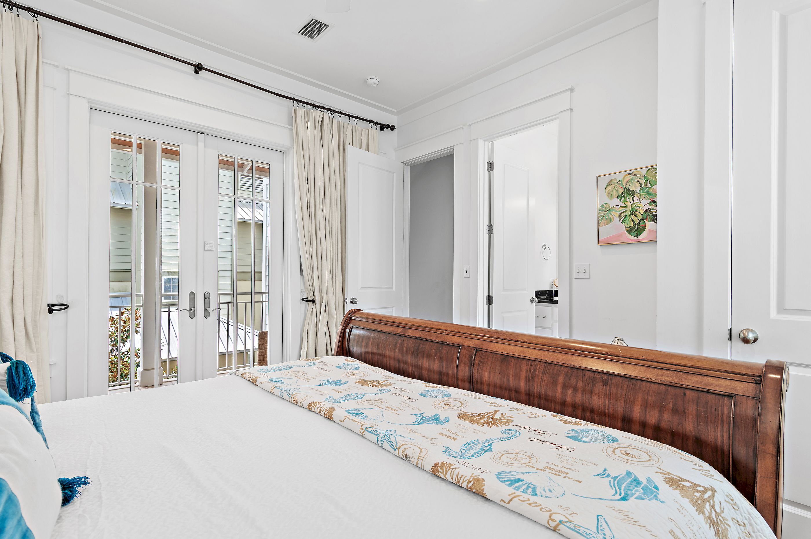 A bedroom with a bed, a wardrobe, a door, and a window with curtains.