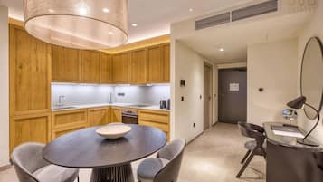 A modern kitchen with wooden cabinets, a round dining table with chairs, and a pendant light.