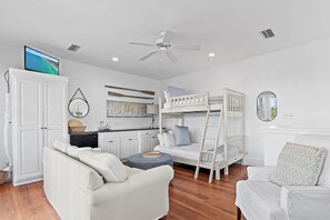 A room with a bunk bed, a desk, a chair, a television, and a ceiling fan. - 🏖️Walk to Beach | 4 Bikes | Fleur de Sea Main House🏖️ (Inlet Beach)