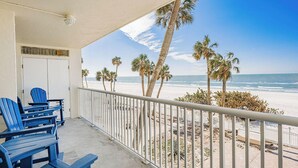 A balcony with a view of the beach, palm trees, and ocean. - Stunning Sand Castle I 308 (Indian Shores)
