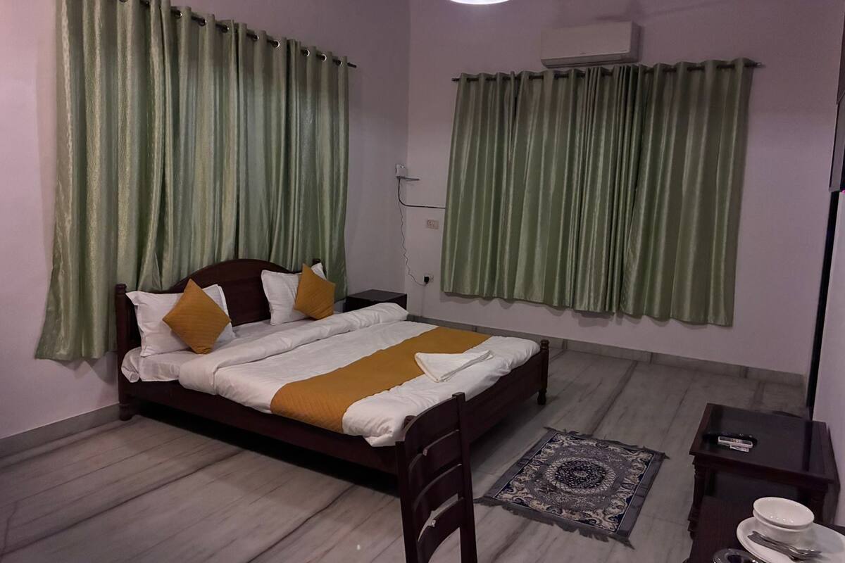 Une chambre à coucher avec un lit, une chaise, une petite table et un tapis.