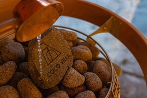 Un pot en cuivre rempli de fèves de cacao et une pierre portant l’inscription « Coco Villa ».