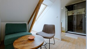 A modern interior with a wooden table, a green sofa, and a brown chair.