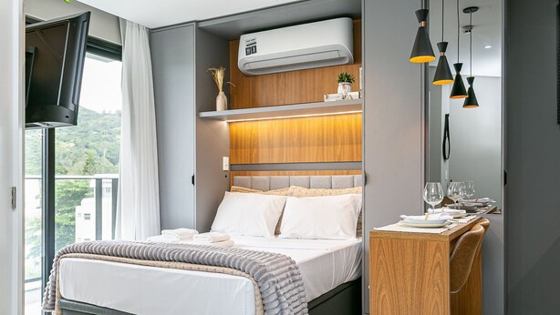 Een moderne slaapkamer met een bed, nachtkastje en televisie.