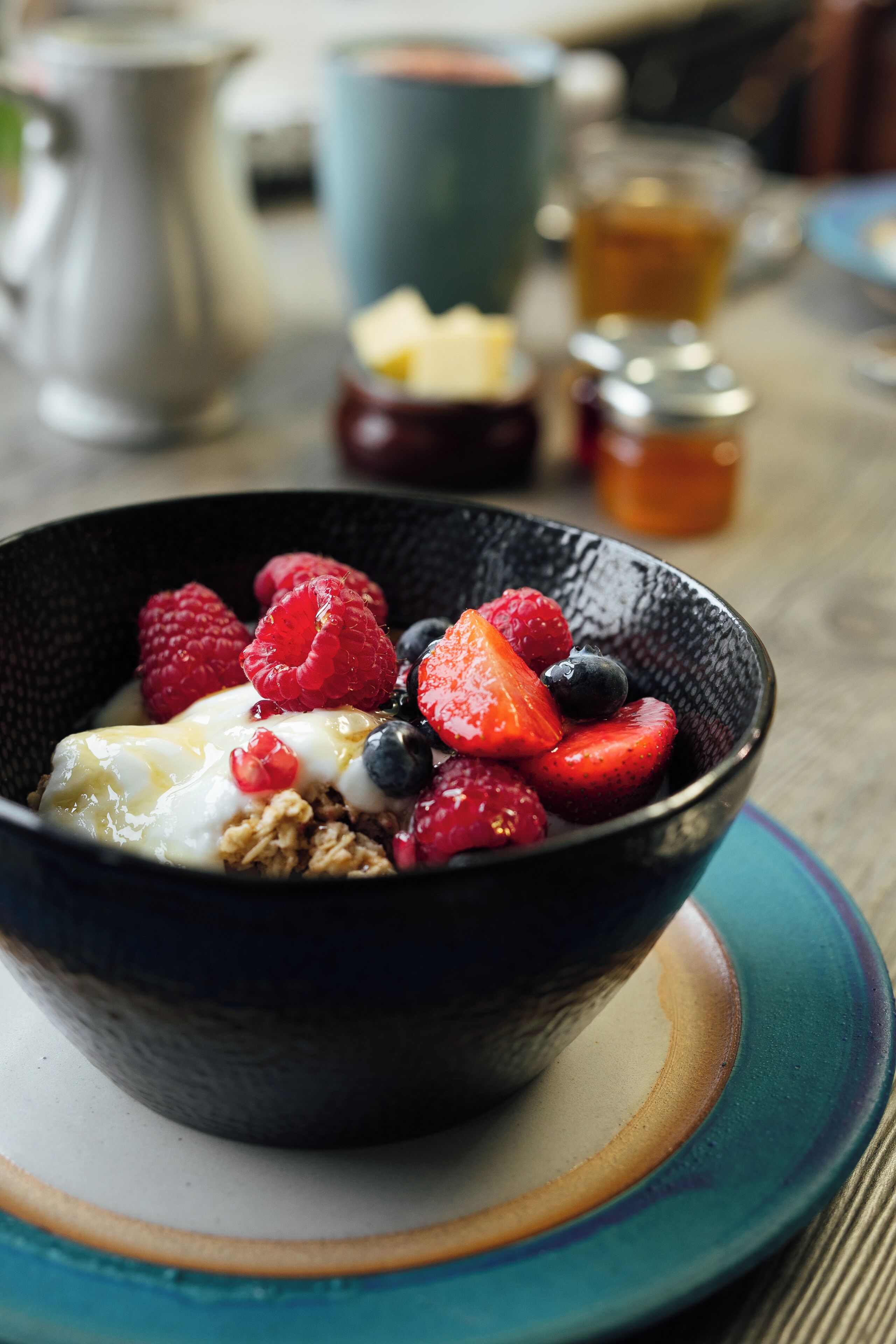 Een schaal fruit en yoghurt op een tafel.