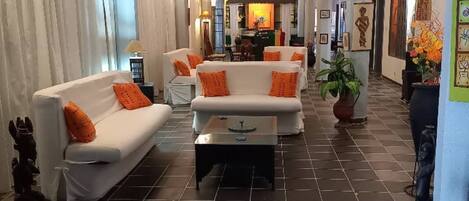 A hotel lobby with a central seating area, a bar, and artwork on the walls.