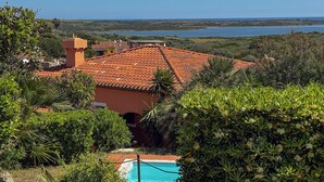 A house with a swimming pool, surrounded by lush greenery and a view of the sea. - Villa Gilda: Private Pool, Charm & Relax (Punta de Su Turrione)
