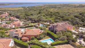 A residential area with houses, a swimming pool, and a view of the sea. - Villa Gilda: Private Pool, Charm & Relax (Punta de Su Turrione)