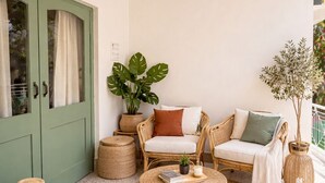 Un salon chaleureux avec une porte verte, des meubles en osier et des guirlandes lumineuses.