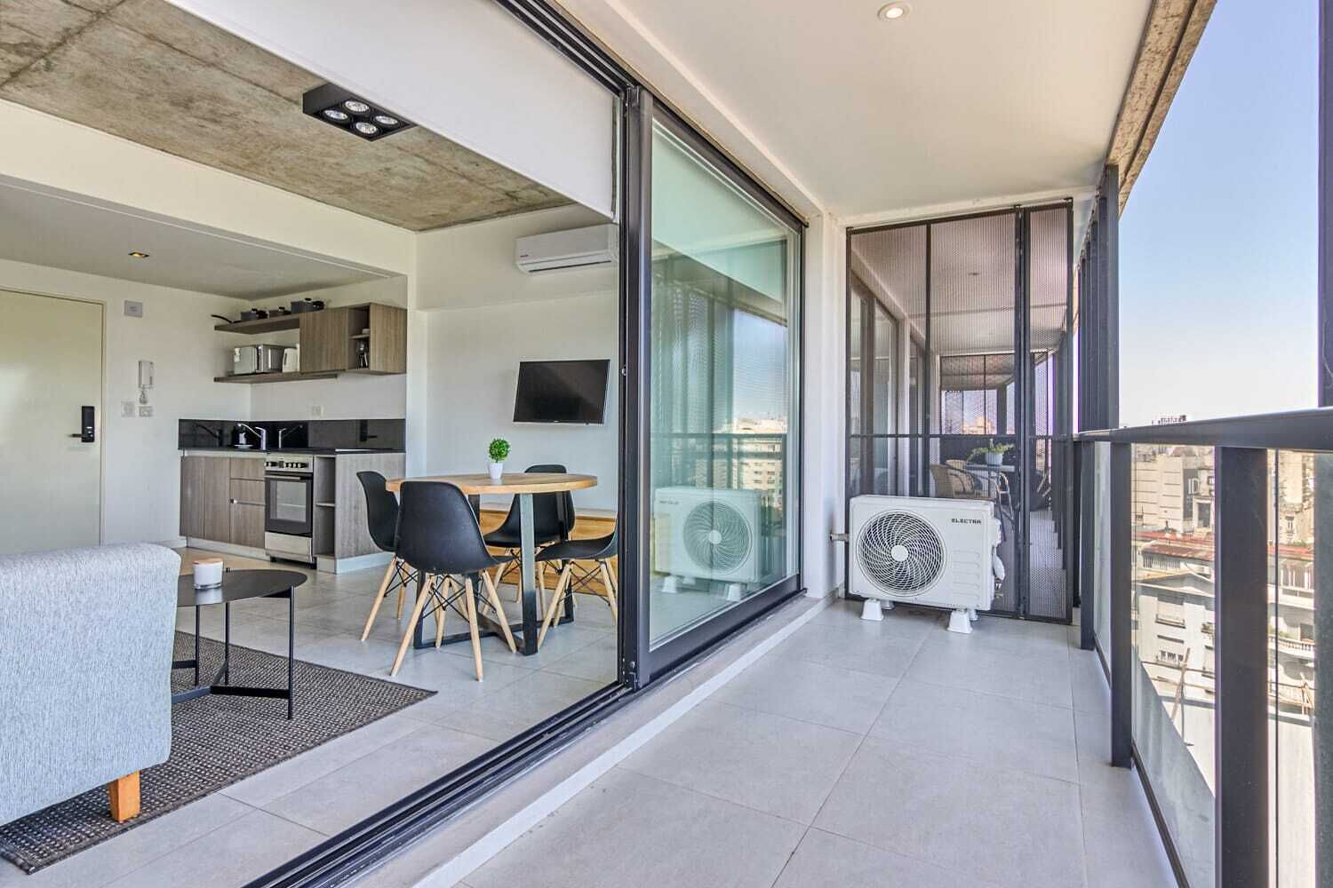 Um apartamento moderno com varanda, cozinha e espaço de jantar.