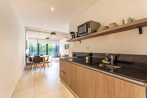 Eine moderne Küche mit schwarzem Arbeitsplatz, Holzschränken und einer eingebauten Mikrowellenregal.