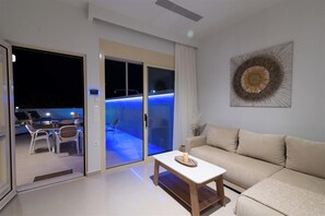 Una sala de estar moderna con un sofá, una mesita de centro y un comedor con sillas y una mesa.