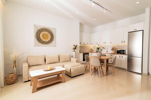 Una sala de estar moderna con sofá, mesa de centro y comedor.