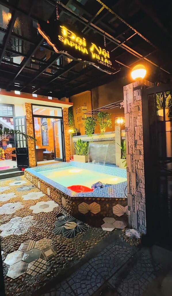 A room with a bed, a small waterfall feature, and a sign above the bed. - DAI NOI SAPHIA HOMESTAY (Hue)