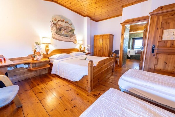 Una habitación con una cama de madera, un armario de madera y un escritorio de madera con una silla.