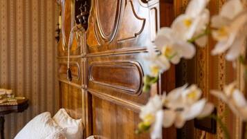 A wooden cabinet with a handle, a small table with items, and white flowers.
