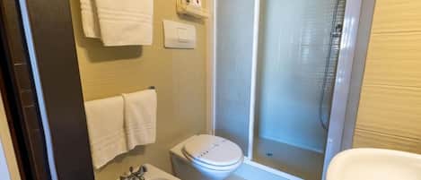 A bathroom with a toilet, sink, and shower.