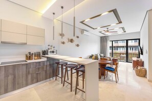 Eine moderne Küche mit einer zentralen Kochinsel, Barhocker und einem Essbereich mit Tisch und Stühlen.