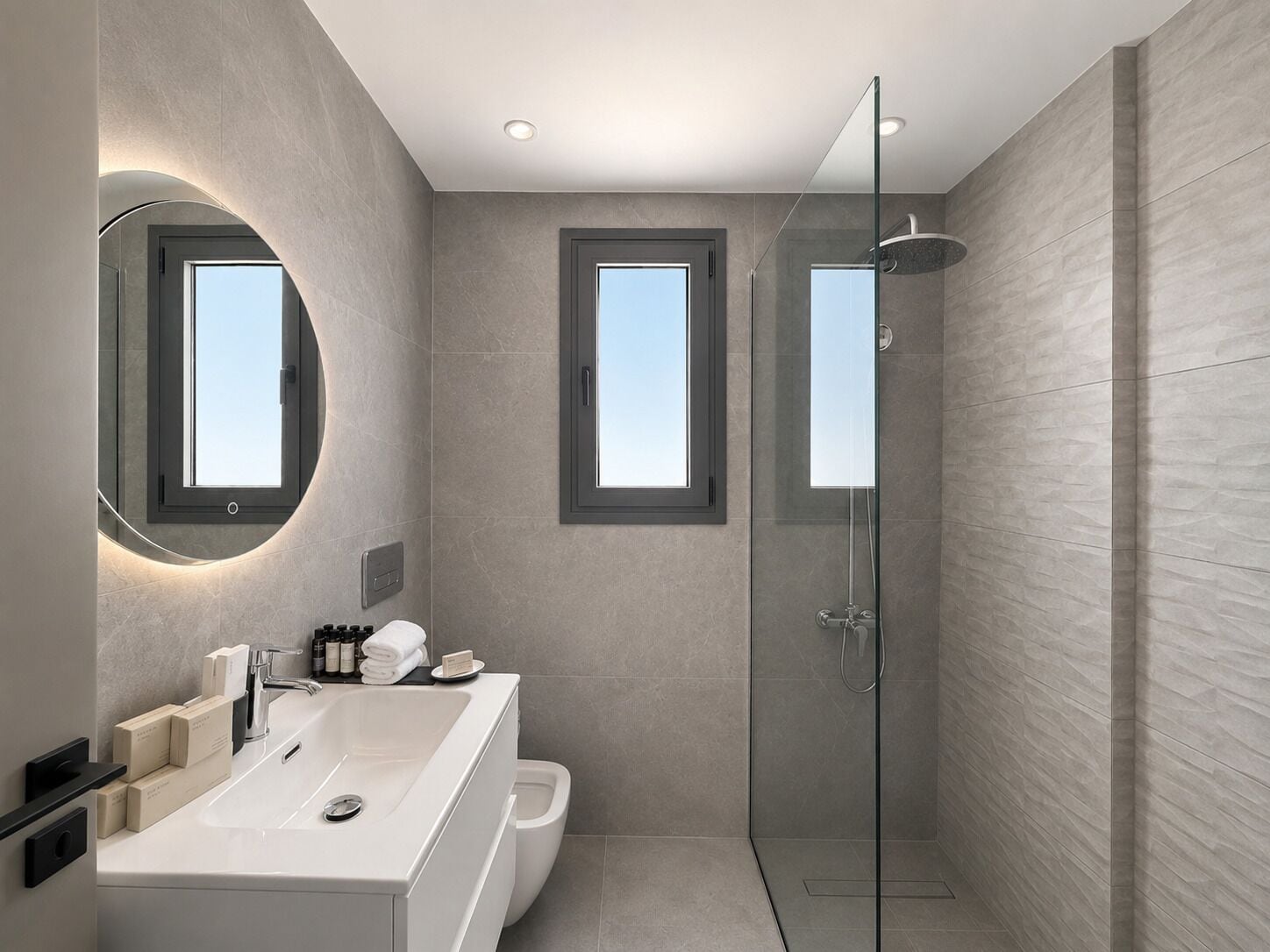 A modern bathroom with a large mirror, a shower, and a window.