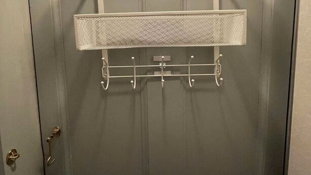 Eine Tür mit einem Metallgestell und Haken zum Aufhängen von Gegenständen.