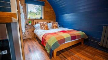 A cozy bedroom with a wooden bed, a colorful blanket, and pillows with 'LOVE' text.
