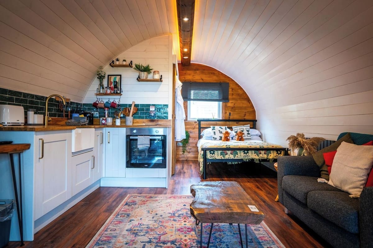 Un interior compacto estilo loft con cocina, comedor y sala de estar.