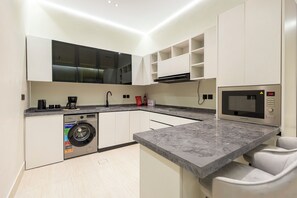 Una cocina moderna con electrodomésticos integrados, lavadora y microondas.