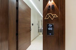 A hotel room entrance with a wooden door, a digital keypad, and a number sign. - Elegant Medina Stay Perfect for Families (Madinah)