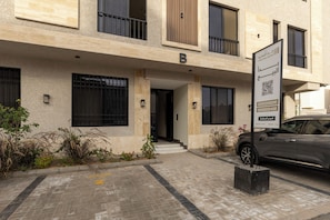 A multi-story building with a sign indicating a property for sale. - Elegant Medina Stay Perfect for Families (Madinah)