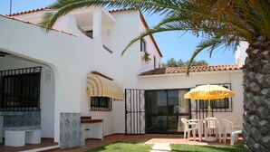 A white building with a tiled roof, a covered patio with a table and chairs, and a palm tree. - Country House 'Quinta Da Eira' with Private Pool, Wi-Fi and Air Conditioning (Lagoa)