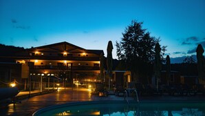 Ett hotell med pool, utomhusservering och en byggnad med flera våningar.