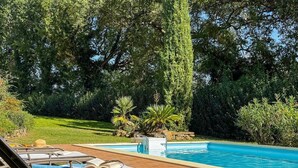 A poolside area with lounge chairs, a pool, and surrounding greenery. - Villa in the Sibillini Mountains, Pool & Privacy (Sant'Angelo in Pontano)